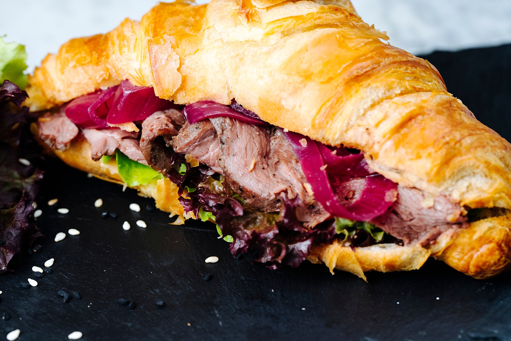 Croissants filled with sliced meat and herbs